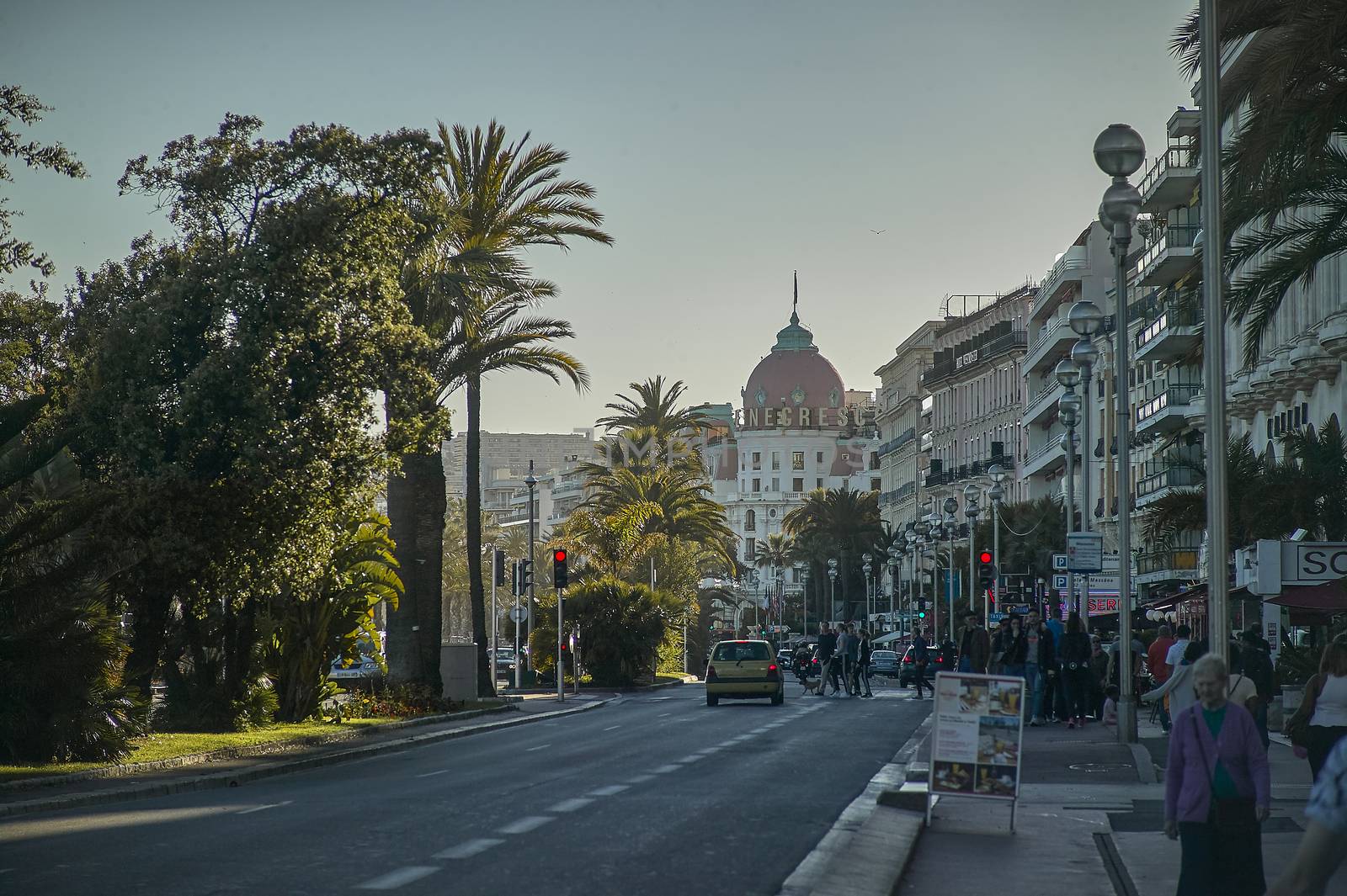 Scene of daily life on the promenade of Nice, city of the French shoreline coast taken during sunset.