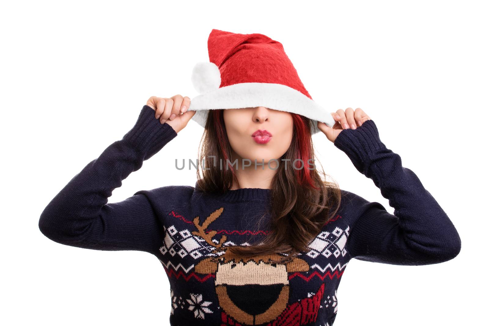 Kisses for the Christmas holidays. Festive beautiful young woman with Santa's hat pulled over her eyes, isolated on white background.