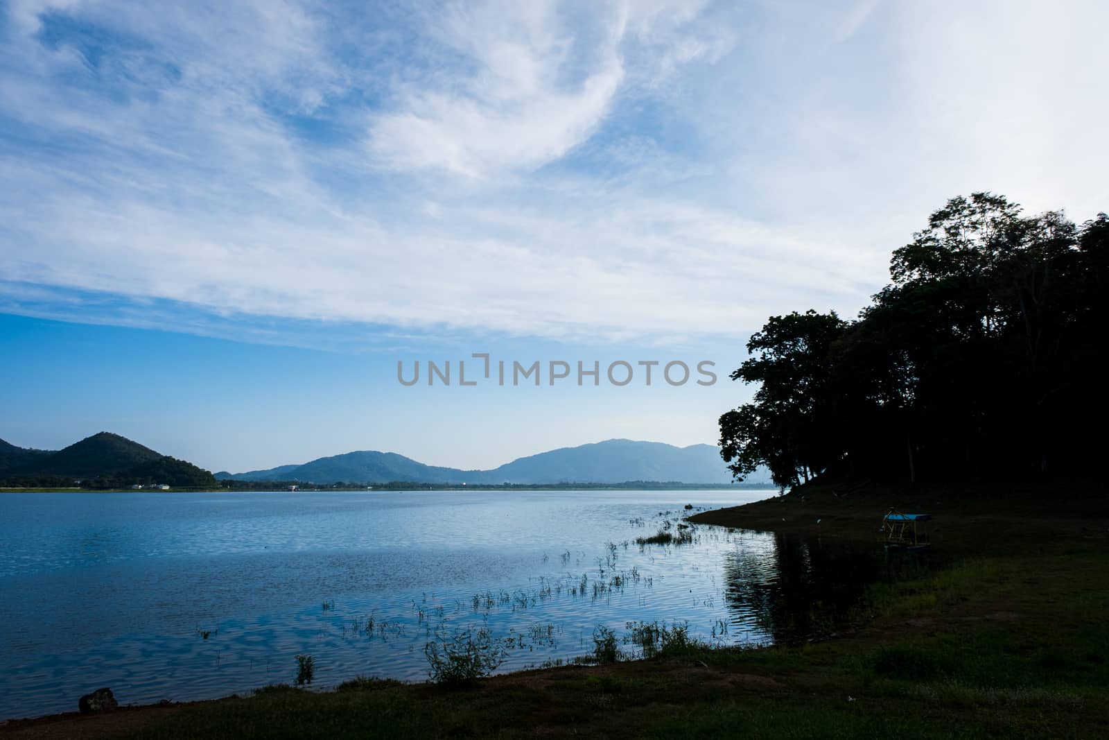 silhouette of bank with white cloudy and lake