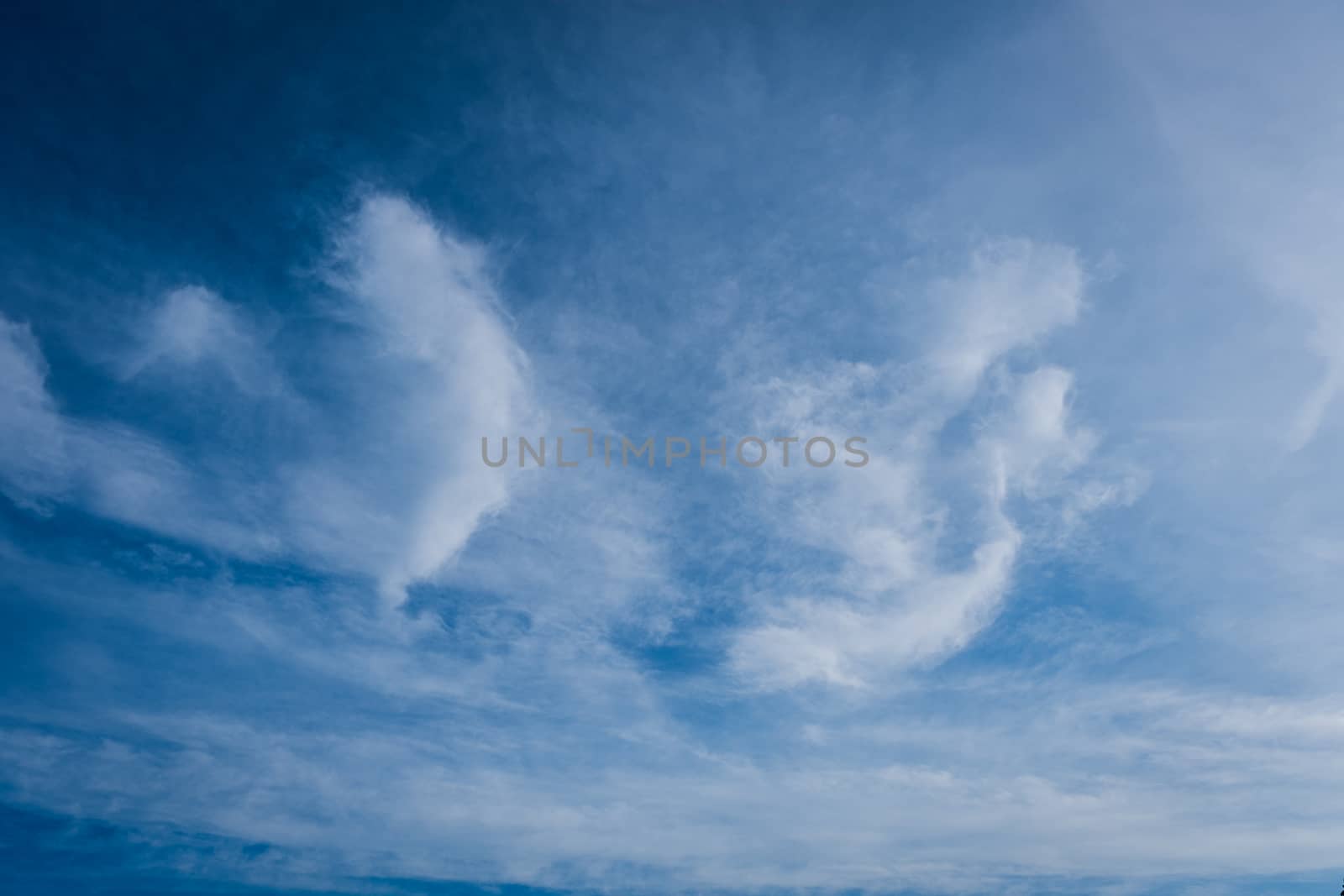 beautiful background of clouds, clearly visible lines of white clouds and blue sky, the top is a sunbeam