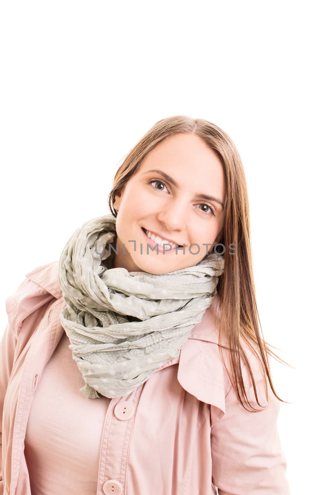 Portrait of a smiling beautiful young woman wearing a pink raincoat and a fashionable scarf, isolated on white background.