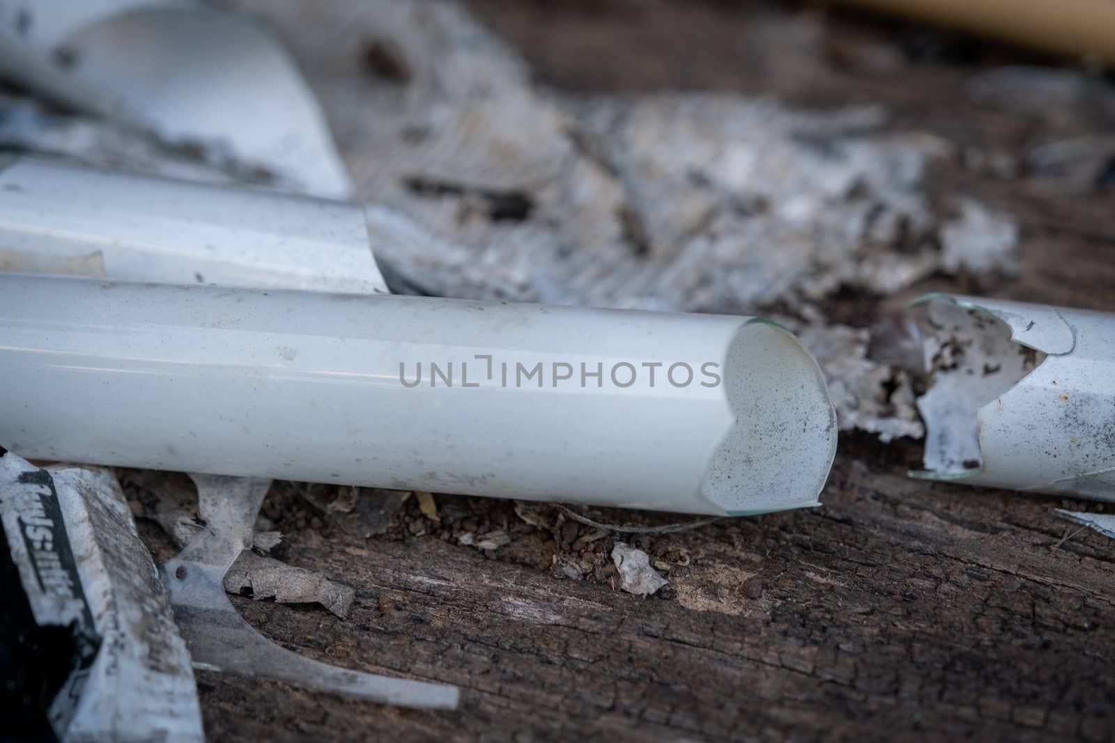 The select focus Pile of broken fluorescent light bulb is danger for health with blur background by peerapixs