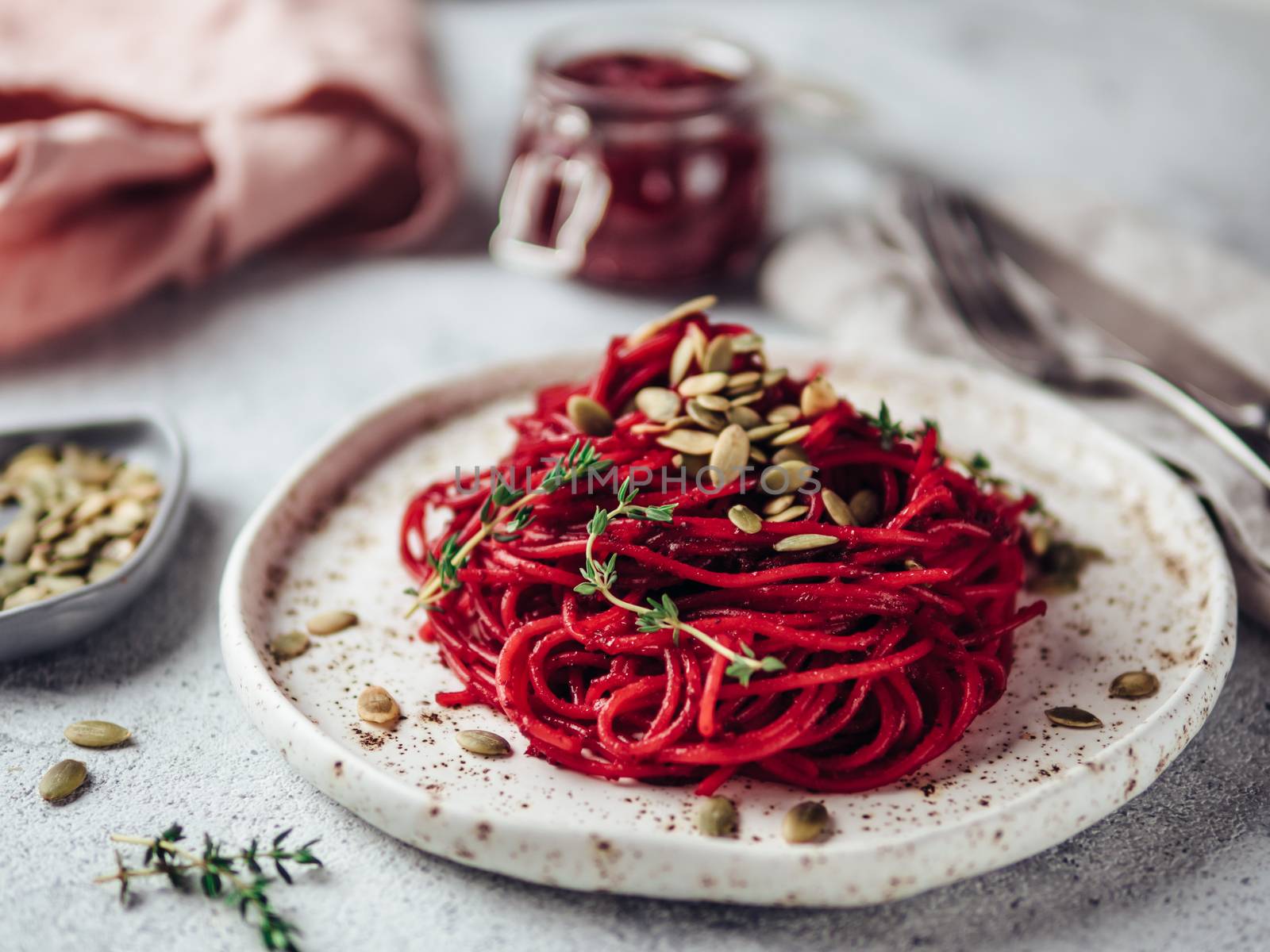 Beetroot pesto or hummus. Homemade beet pesto sauce in glass jar and fresh thyme on dark black background. Copy space for text. Ideas and recipes for healthy vegetarian detox diet food