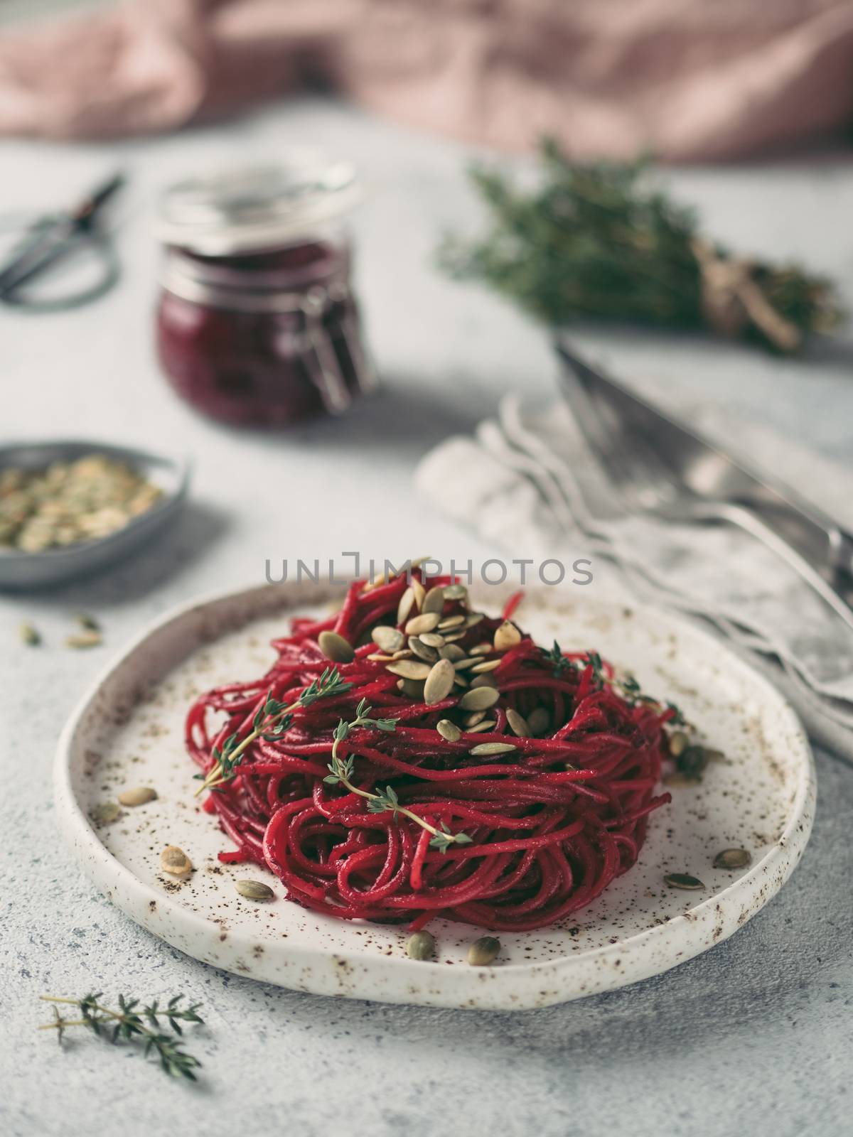 Beetroot pesto or hummus. Homemade beet pesto sauce in glass jar and fresh thyme on dark black background. Copy space for text. Ideas and recipes for healthy vegetarian detox diet food