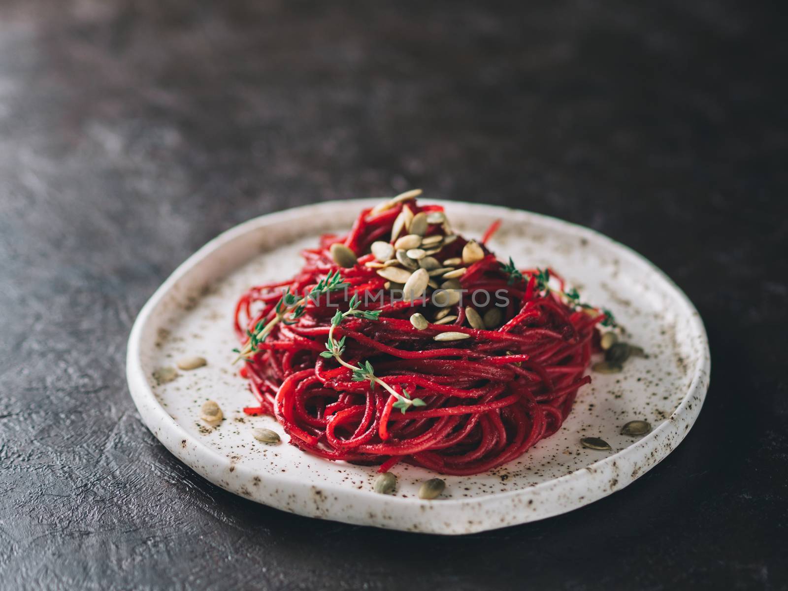 Beetroot pesto or hummus. Homemade beet pesto sauce in glass jar and fresh thyme on dark black background. Copy space for text. Ideas and recipes for healthy vegetarian detox diet food