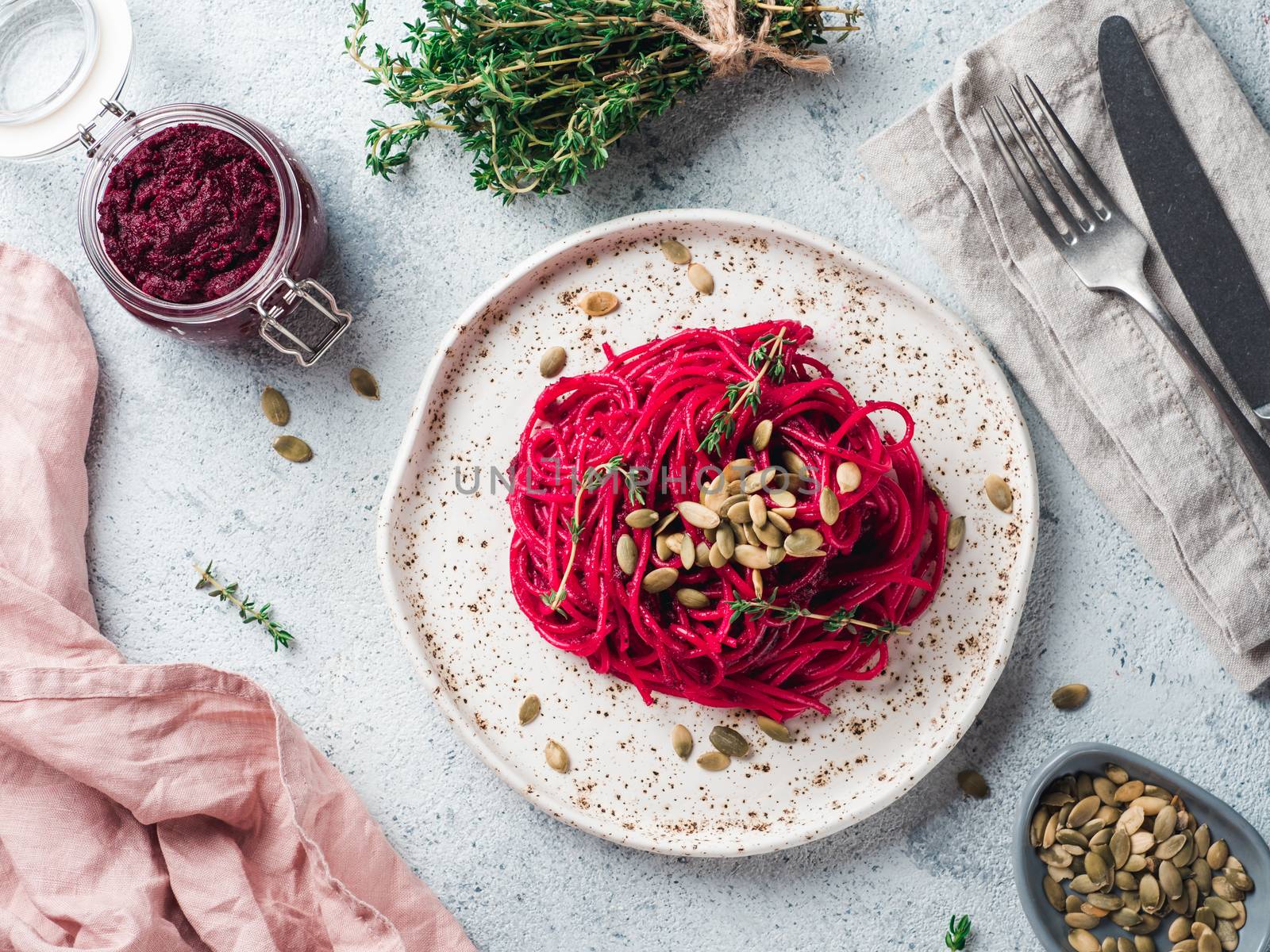 Beetroot pesto or hummus. Homemade beet pesto sauce in glass jar and fresh thyme on dark black background. Copy space for text. Ideas and recipes for healthy vegetarian detox diet food