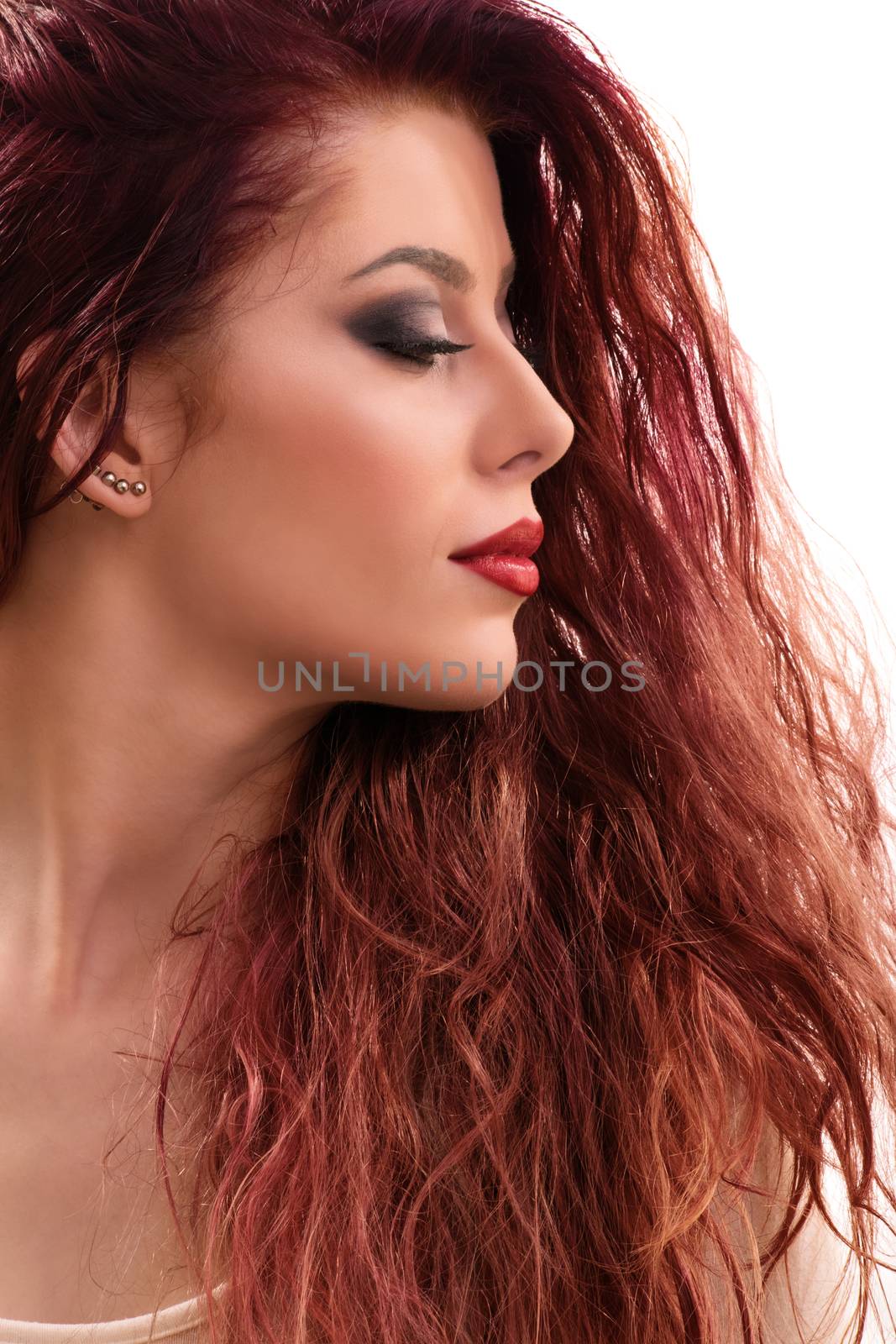 Close up profile shot of a sensual beautiful redhead young woman with smoky make up with closed eyes, isolated on white background.