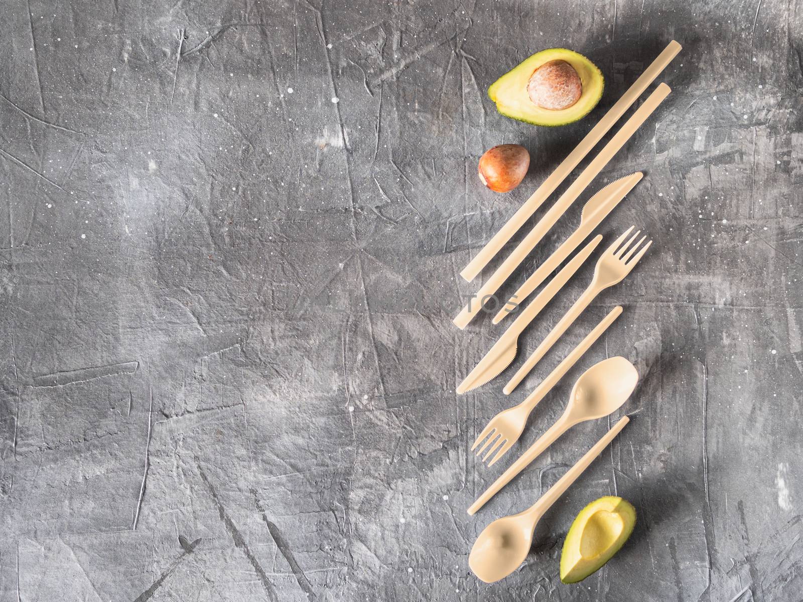 Avocado Seeds Biodegradable Single-Use Cutlery. Bioplastic - Great alternative to plastic disposable cutlery. Top view, flat lay. Gray background