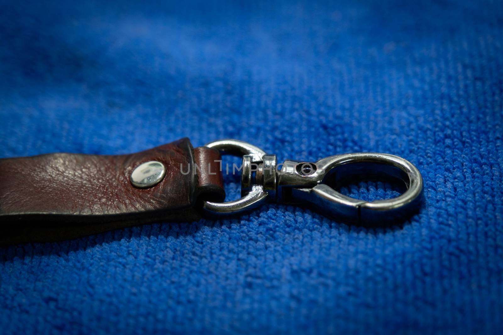 A Select focus Leather key chain with box on blue fabric background by peerapixs