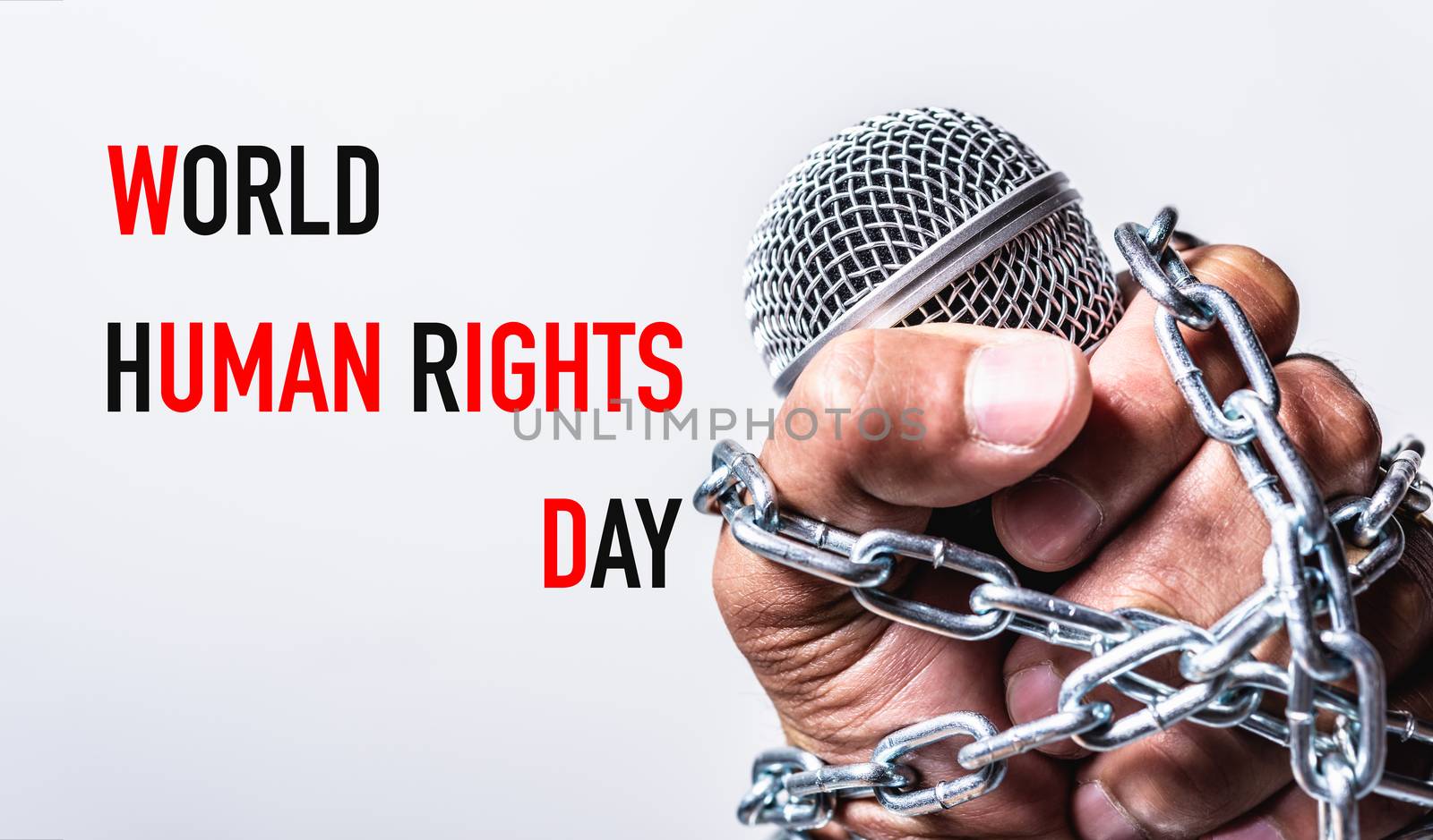 Rope and chain on fist hand with world HUMAN RIGHTS DAY text
 by Sorapop