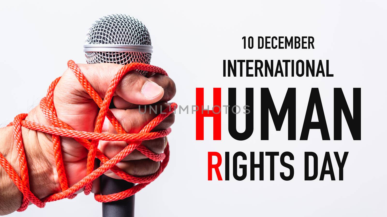 Hand holding microphone and have roped on fist hand with 10 december international HUMAN RIGHTS DAY text on white background, Human rights day concept