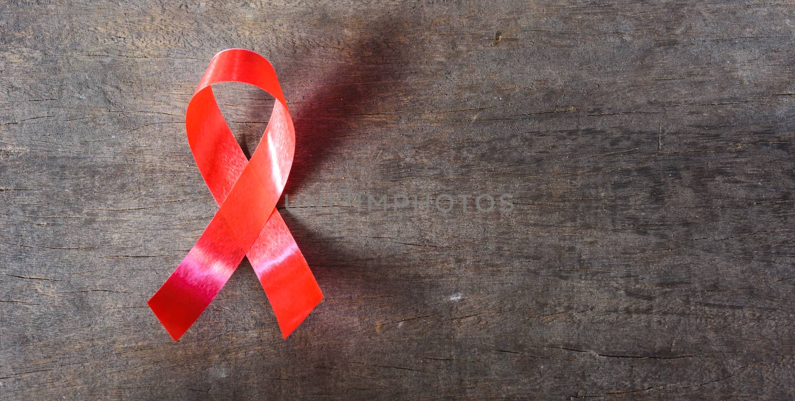 Red Ribbon Support HIV, AIDS on wooden background and copy space for use