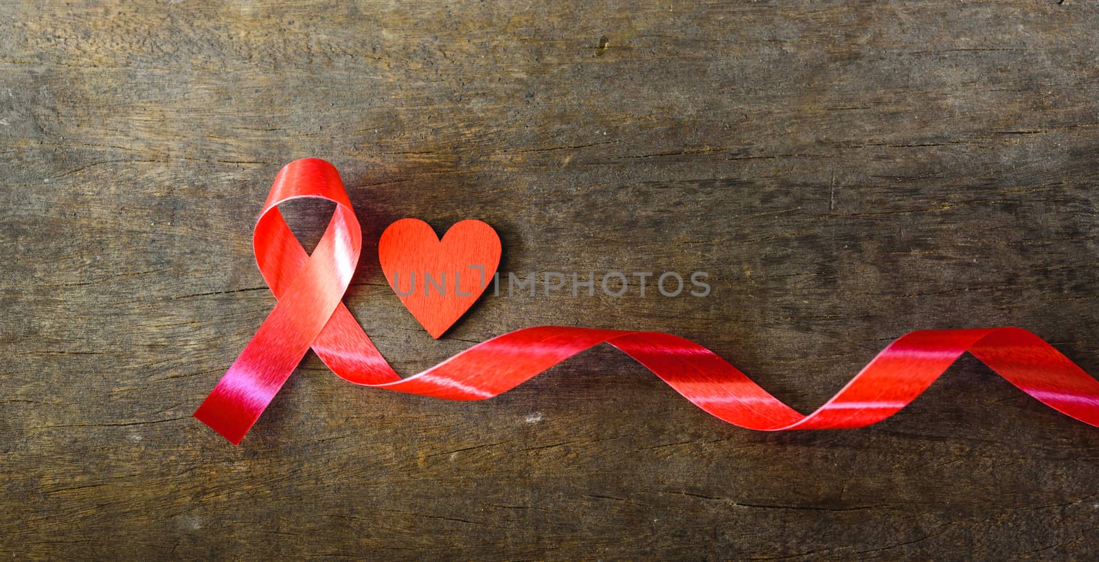 Red Ribbon Support HIV, AIDS and red Heart on wooden background and copy space for use