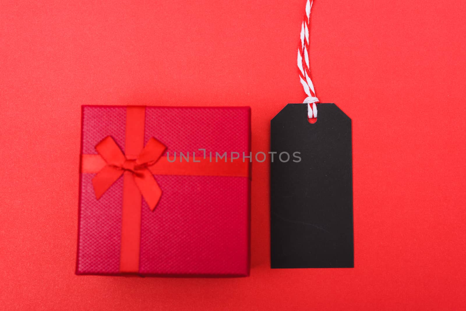 Red tag label and red grift box on black background, blank copy  by Sorapop