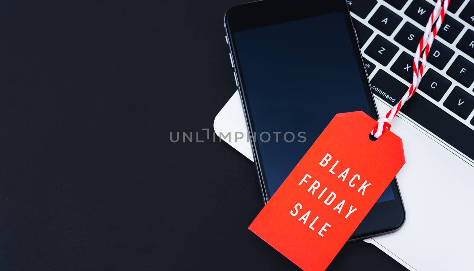 Black Friday Sale text on red tag have mobile smart phone over l by Sorapop