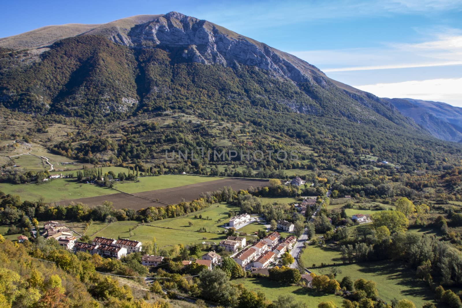 landscape of a sunny valley and mountain peaks as seen from the town of Opi, in Abruzzo national park, Italy