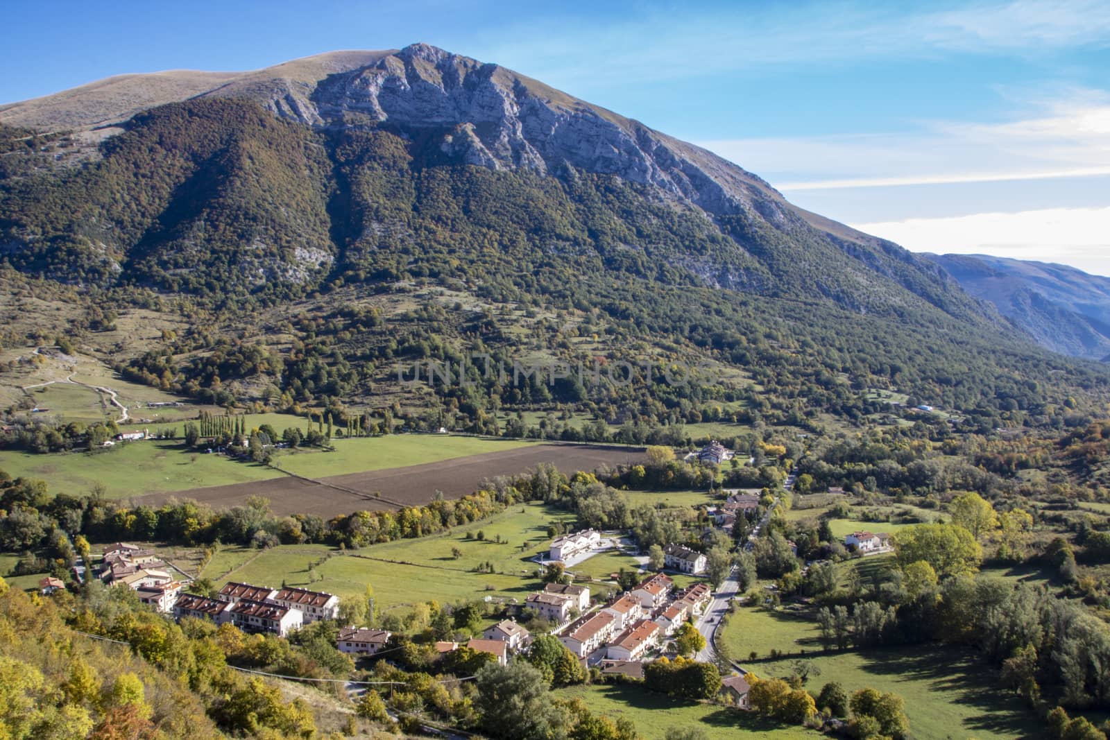 landscape of a sunny valley and mountain peaks as seen from the town of Opi, in Abruzzo national park, Italy