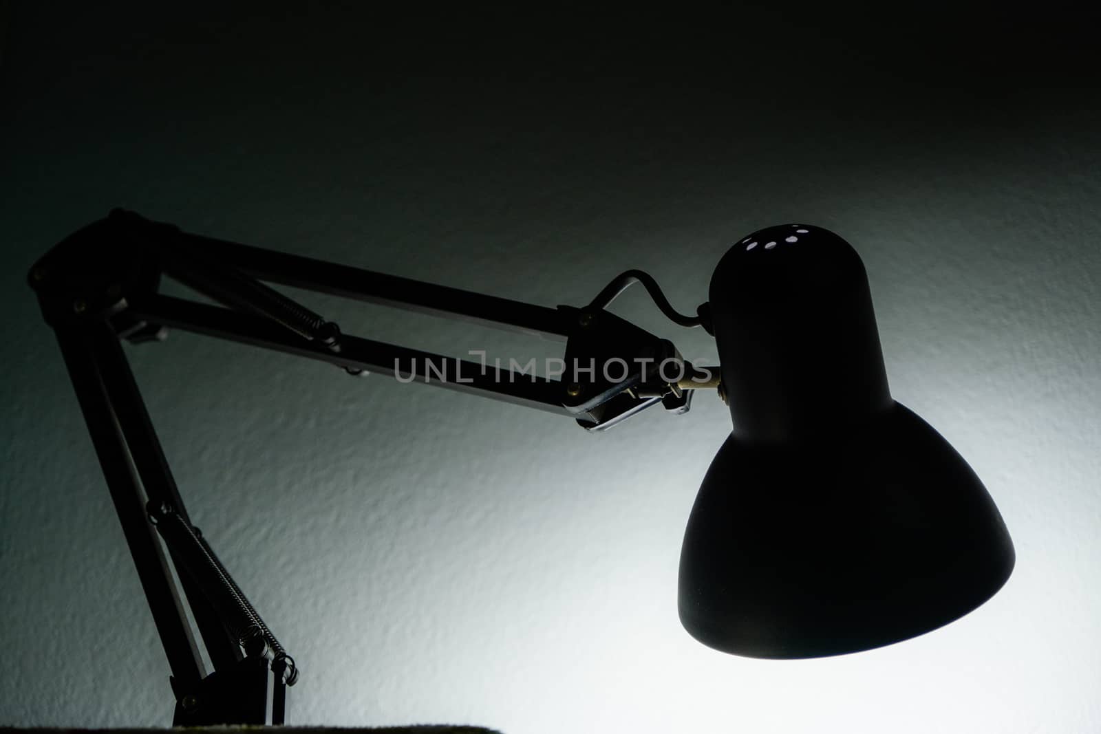 The Silhouette of a table lamp on the background of a window in the morning at dawn, work until morning, work at night.