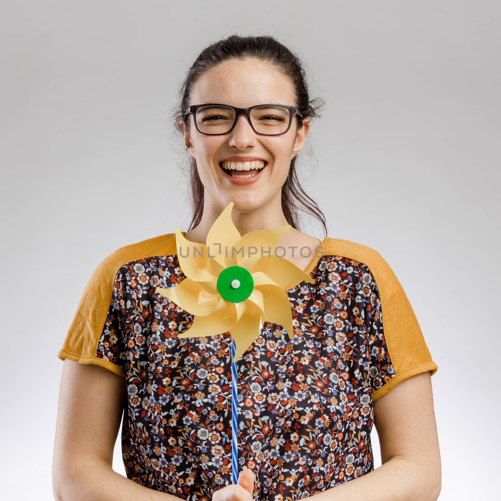 Portrait of a happy woman playing with a windmill