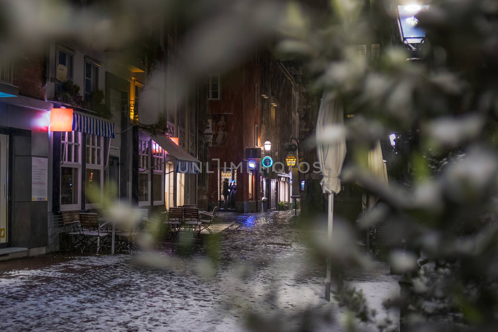 Snowy empty street at night in Aachen, Germany - lights and reflections