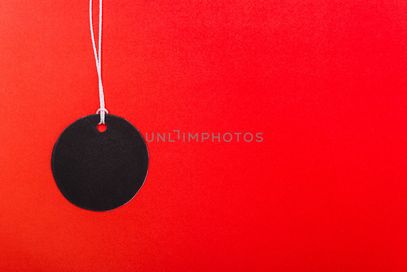 Circle Black tag label on red background, with copy space