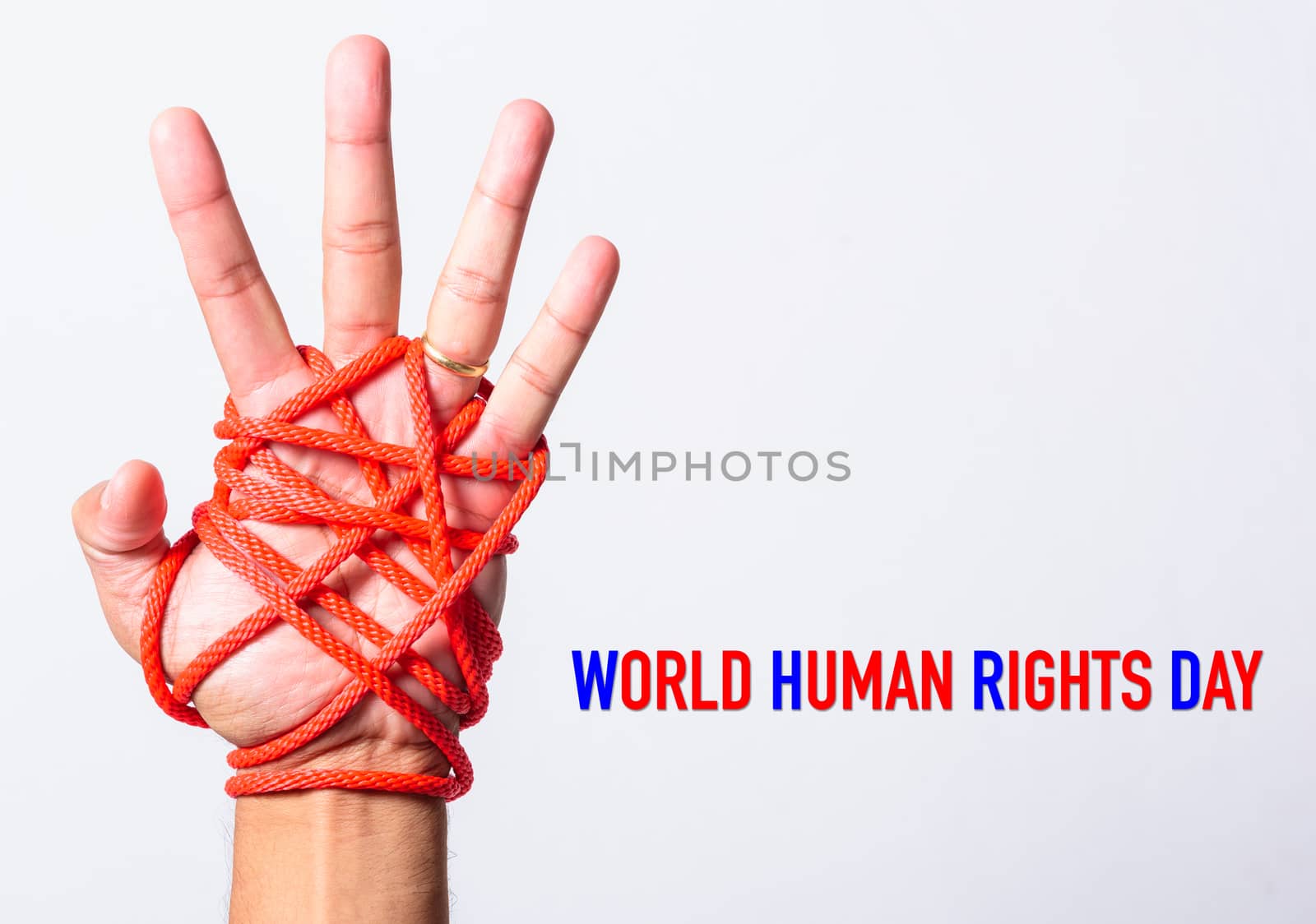 Red rope on lift hand with WORLD HUMAN RIGHTS DAY text on white  by Sorapop