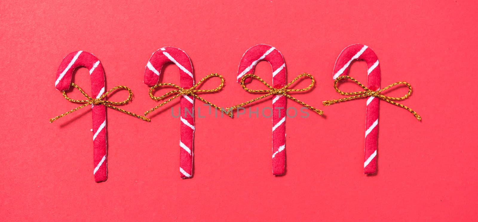 Christmas 4 candies candy cane on red background by Sorapop