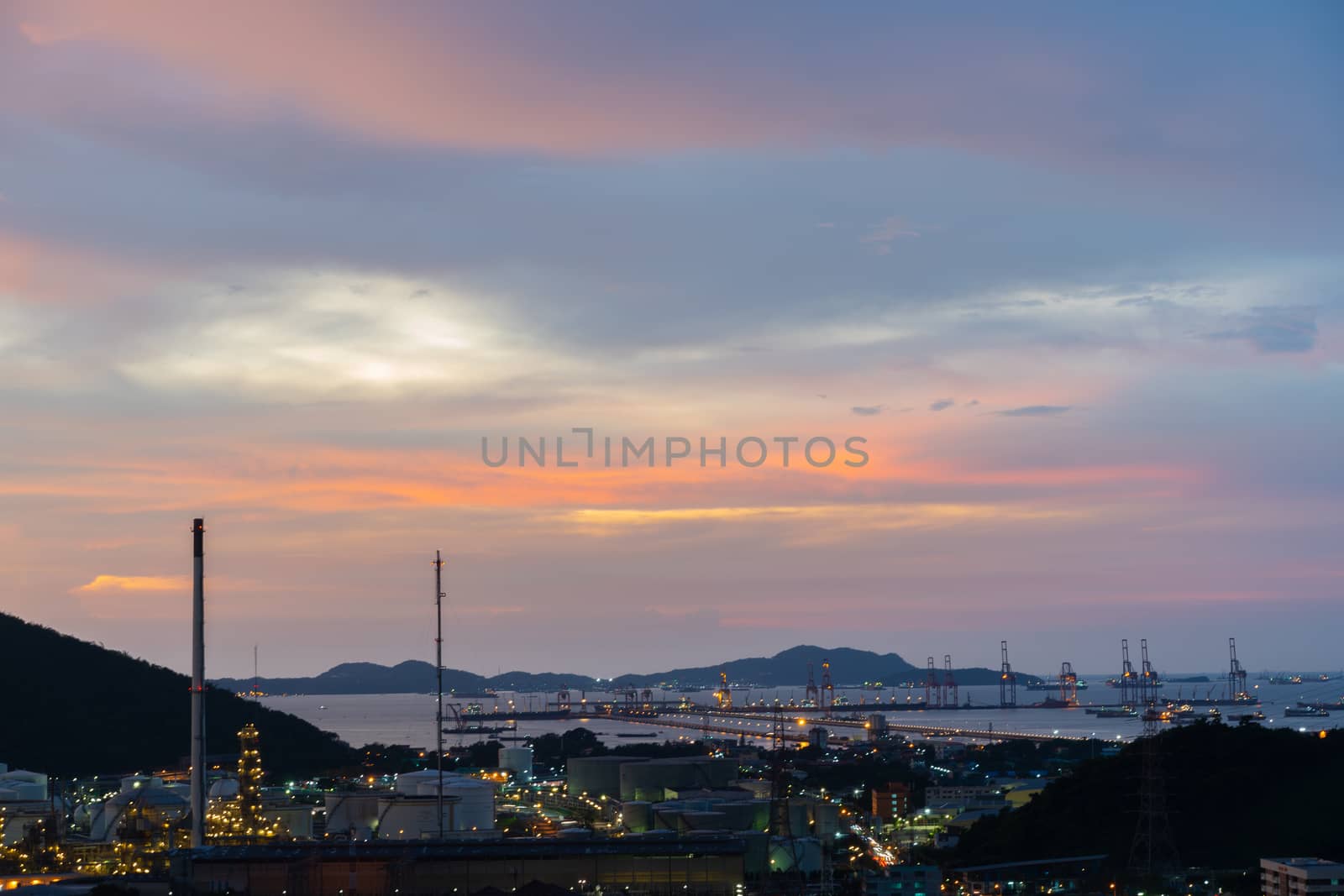 Oil Or Gas Refinery At Sunset. A silhouette of an oil or gas industrial refinery at sunset with a colourful sky behind by peerapixs