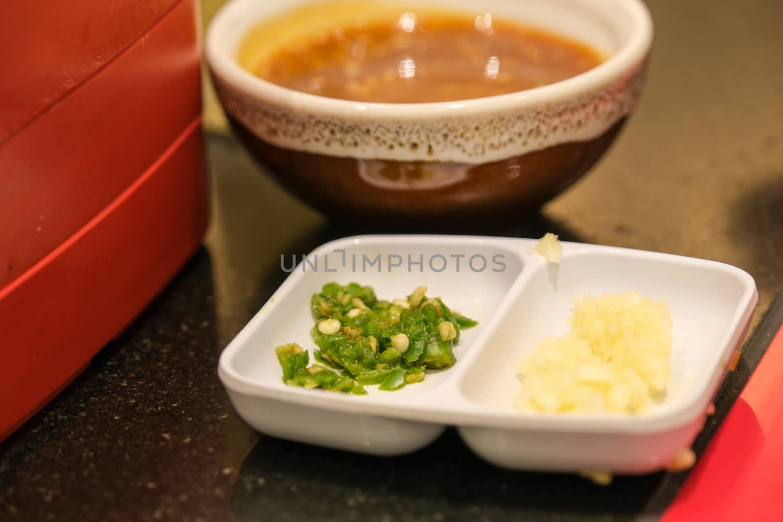 close up sesame and soy sauce with a glass of minced chili and garlic