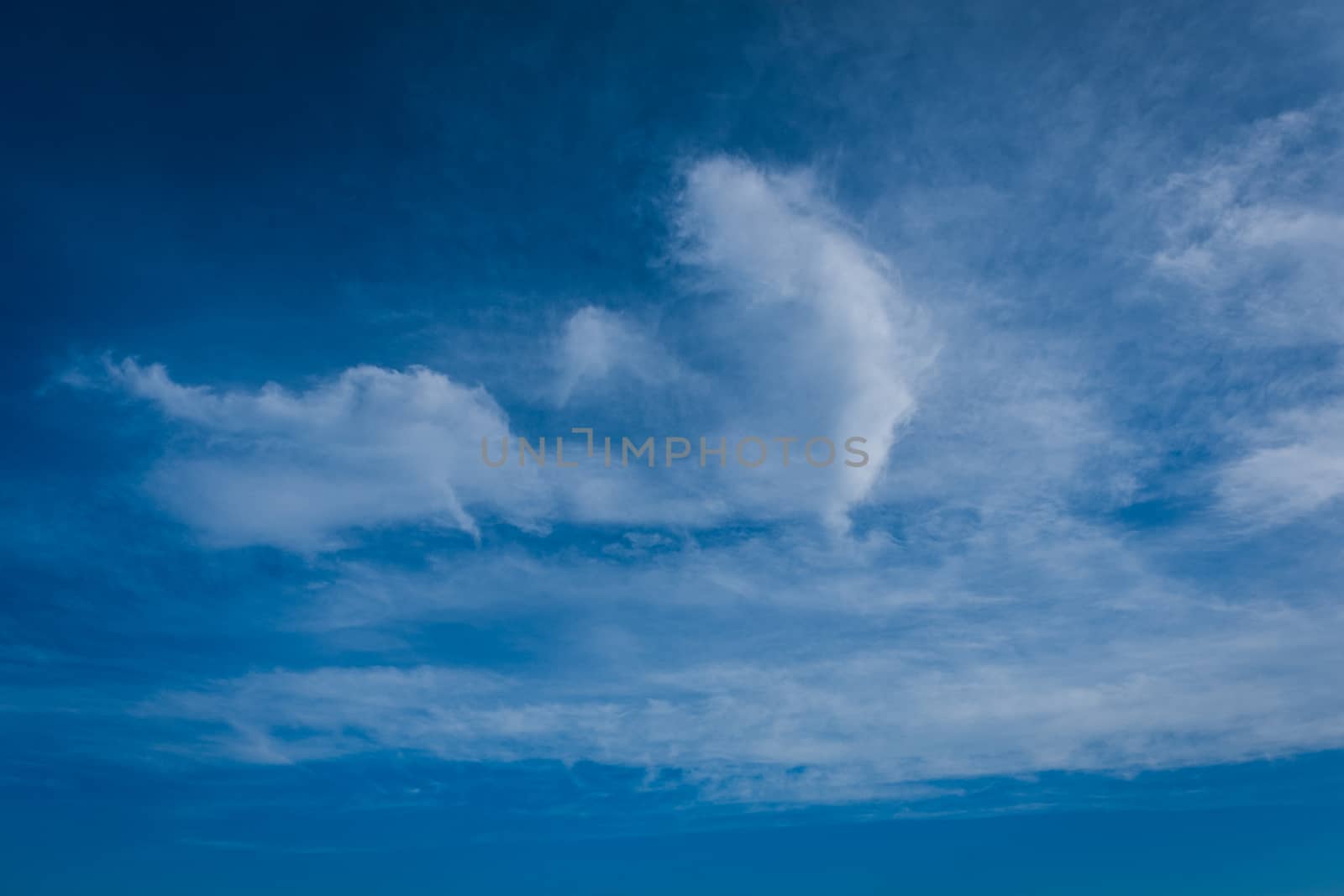 The beautiful background of clouds, clearly visible lines of white clouds and blue sky, the top is a sunbeam