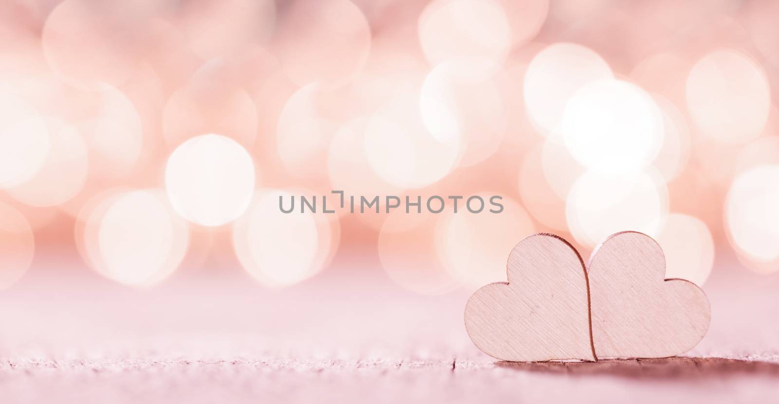 Two handmade wooden pink hearts on beautiful bokeh background. Vintage style. Love Valentine's Day concept.