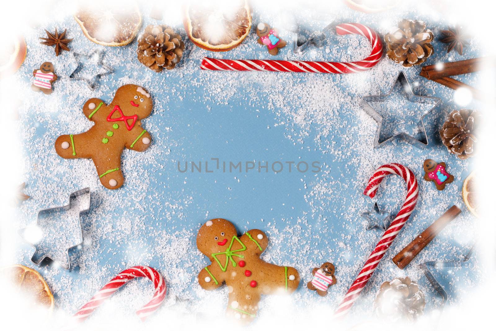 Christmas food frame. Gingerbread cookies, spices and decorations on blue background with copy space