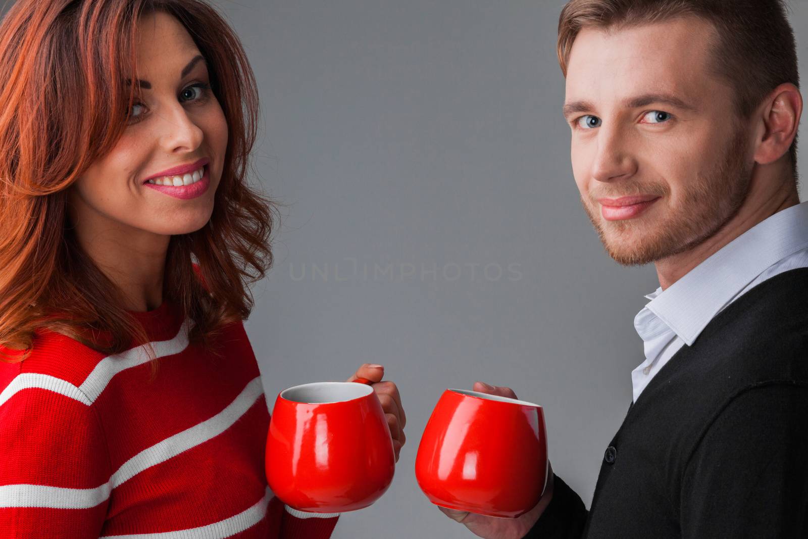 Portrait of couple holding red coffee cups, Christmas or Valentines day concept