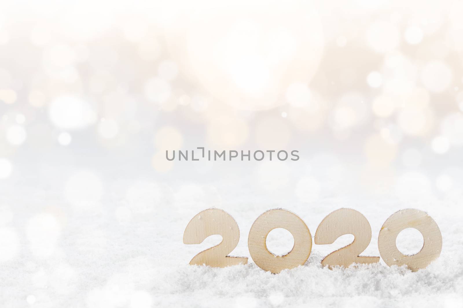 Wooden Number 2020 in the snow , Happy New Year's concept on glitter bokeh background
