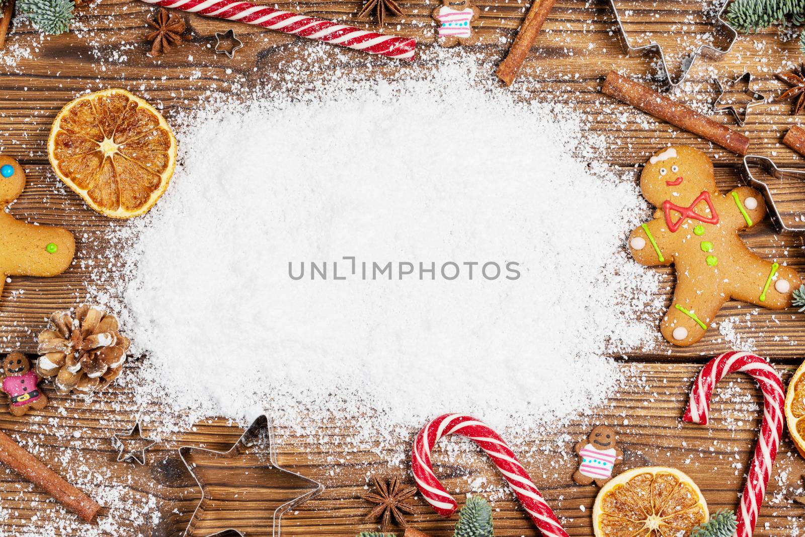 Christmas food frame. Gingerbread cookies, spices and decorations on wooden background with copy space on snow