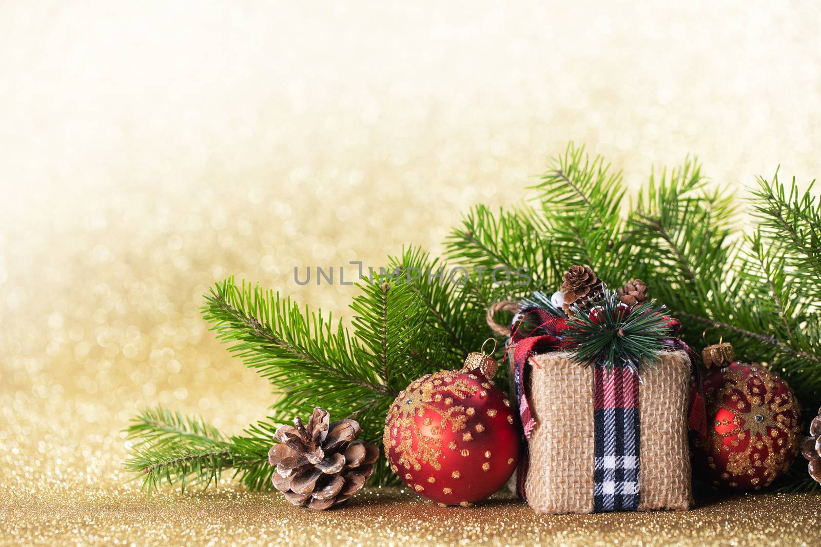 Christmas toys, decorations, present gift box wrapped in kraft paper on golden glitter background, copy space