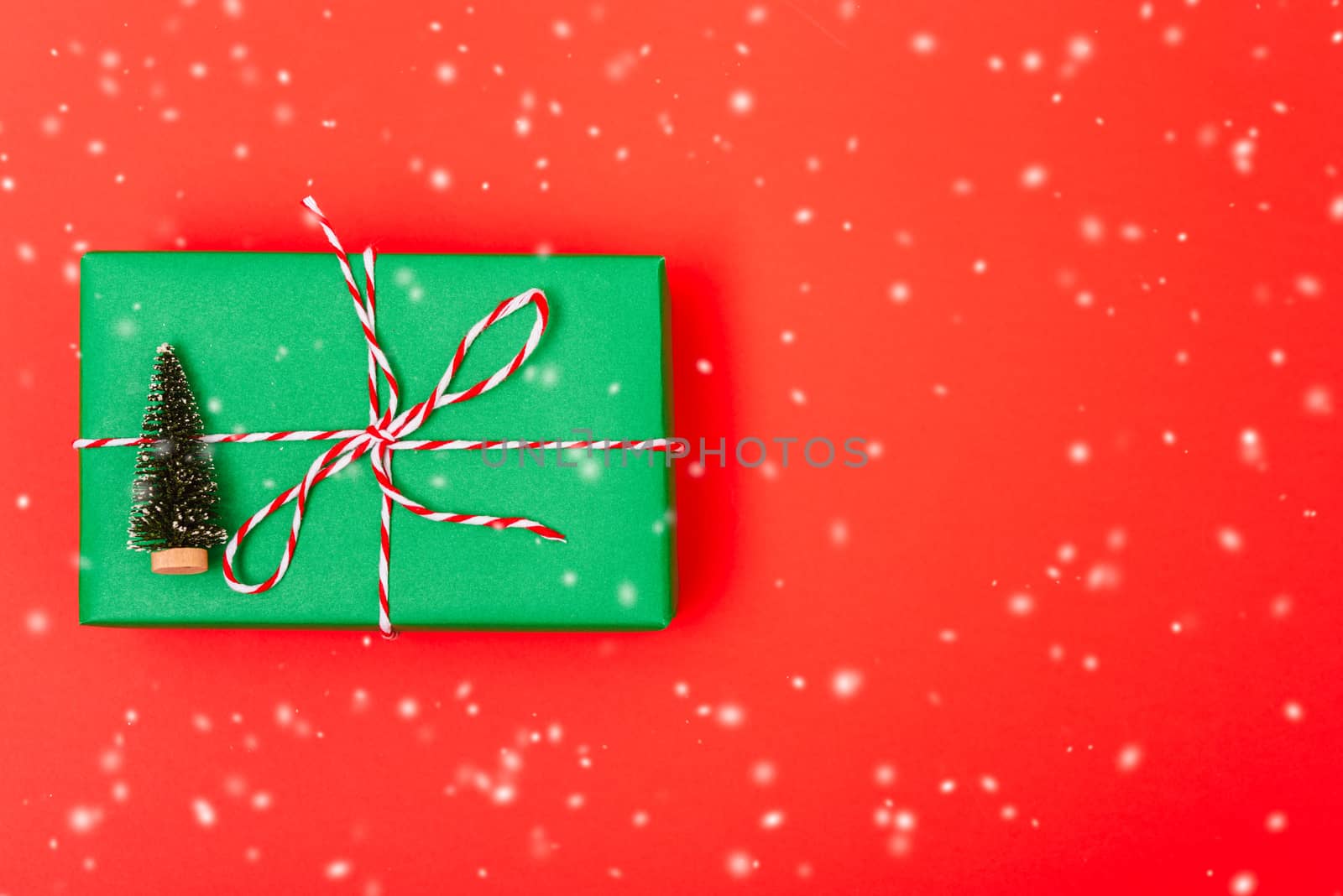 New Year, Christmas Xmas holiday composition, Top view gift green box, clews of rope and green fir tree branch on red background with copy space