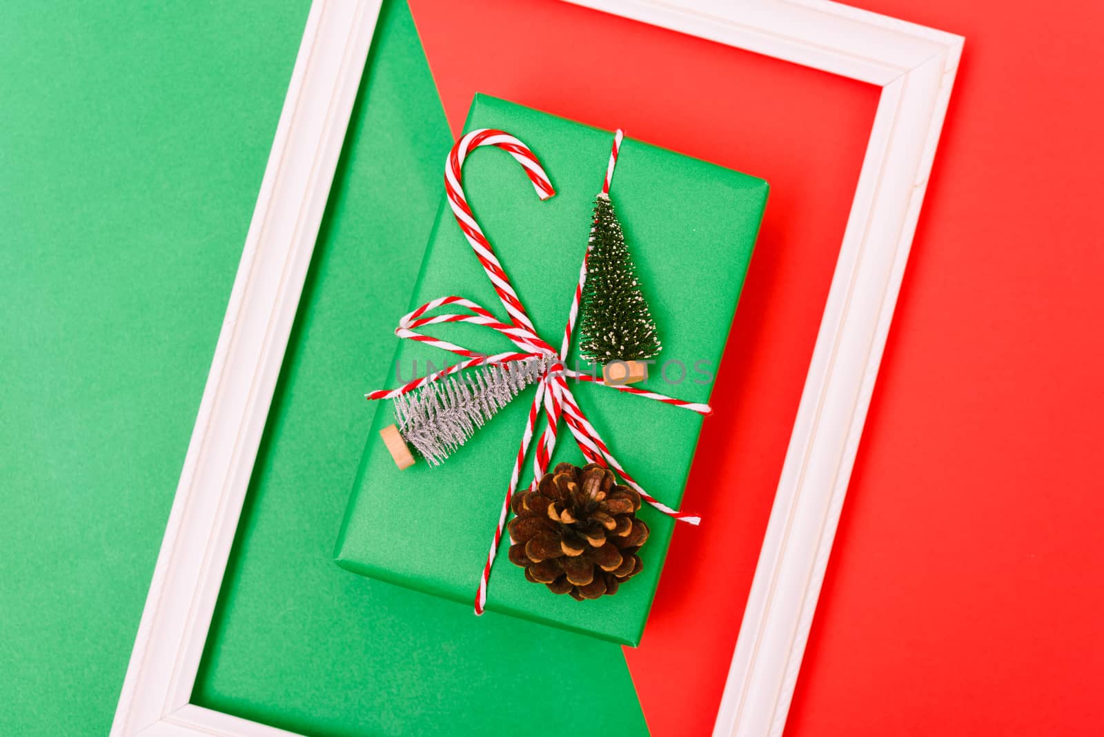 New Year, Christmas Xmas holiday composition, Top view gift green box, clews of rope, green fir tree branch on red and green background with copy space