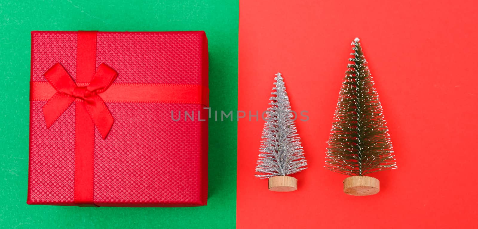 New Year, Christmas Xmas holiday composition, Top view green fir tree branch and red gift box on red and green background with copy space