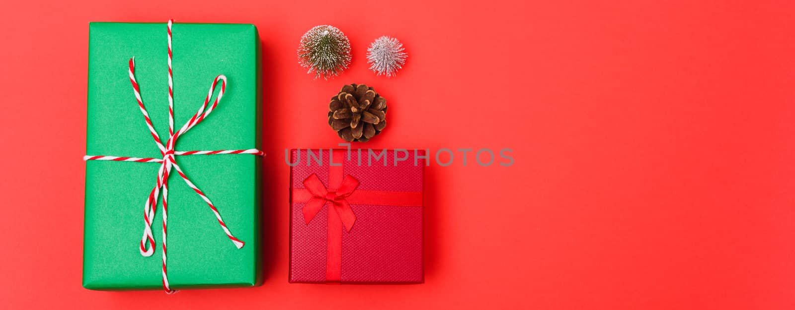 New Year, Christmas Xmas holiday composition, Top view green and red gift box and green fir tree branch on red background with copy space