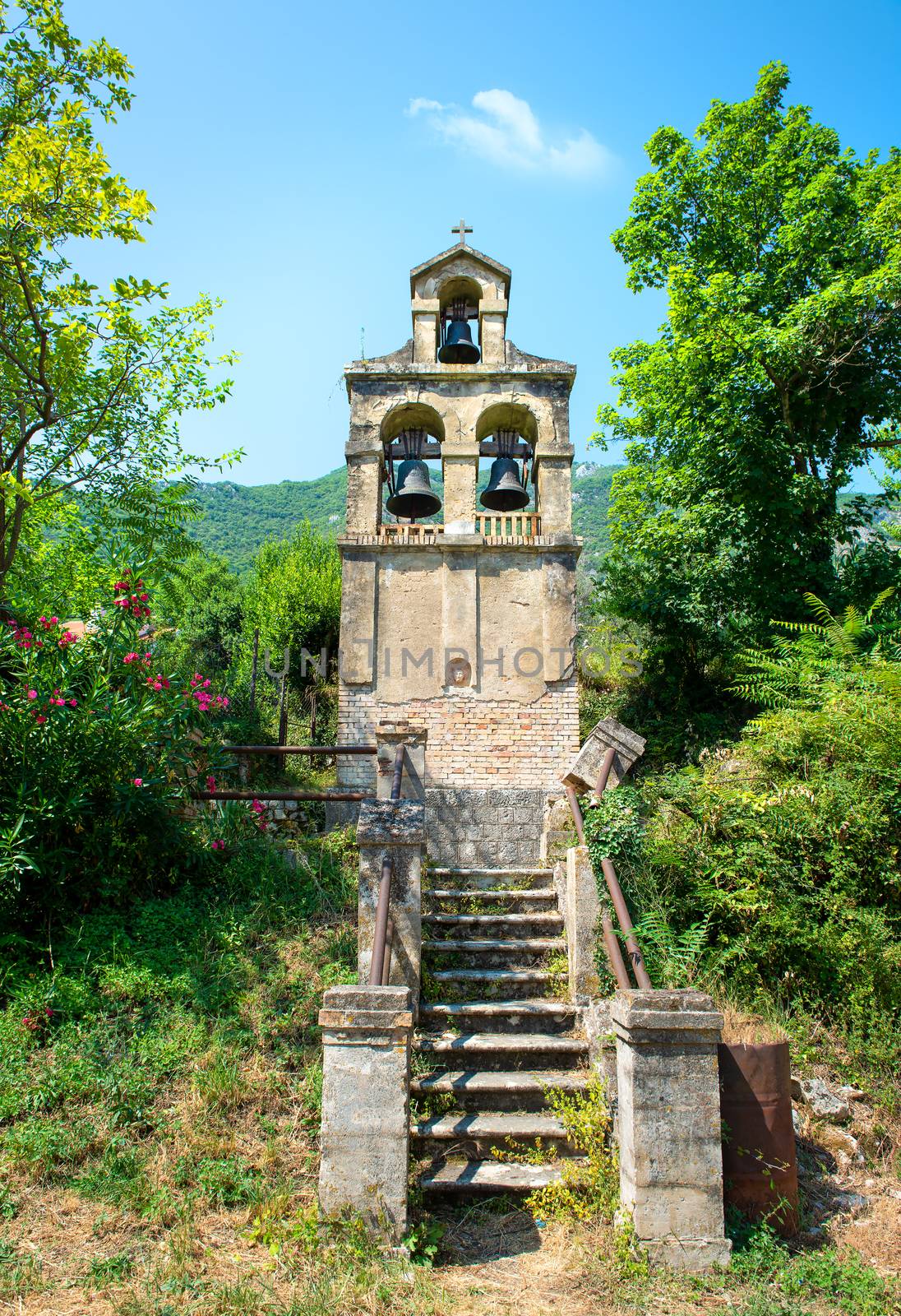Bell tower near the village Prcanj. Montenegro. Separate belfry on the background of the mountain.
