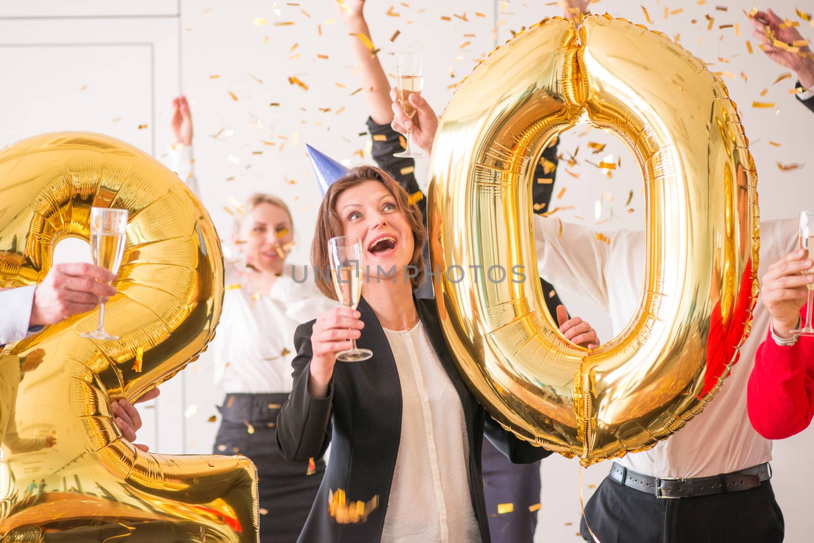Business people are celebrating holiday in modern office drinking champagne and having fun in coworking. Merry Christmas and Happy New Year 2020 concept