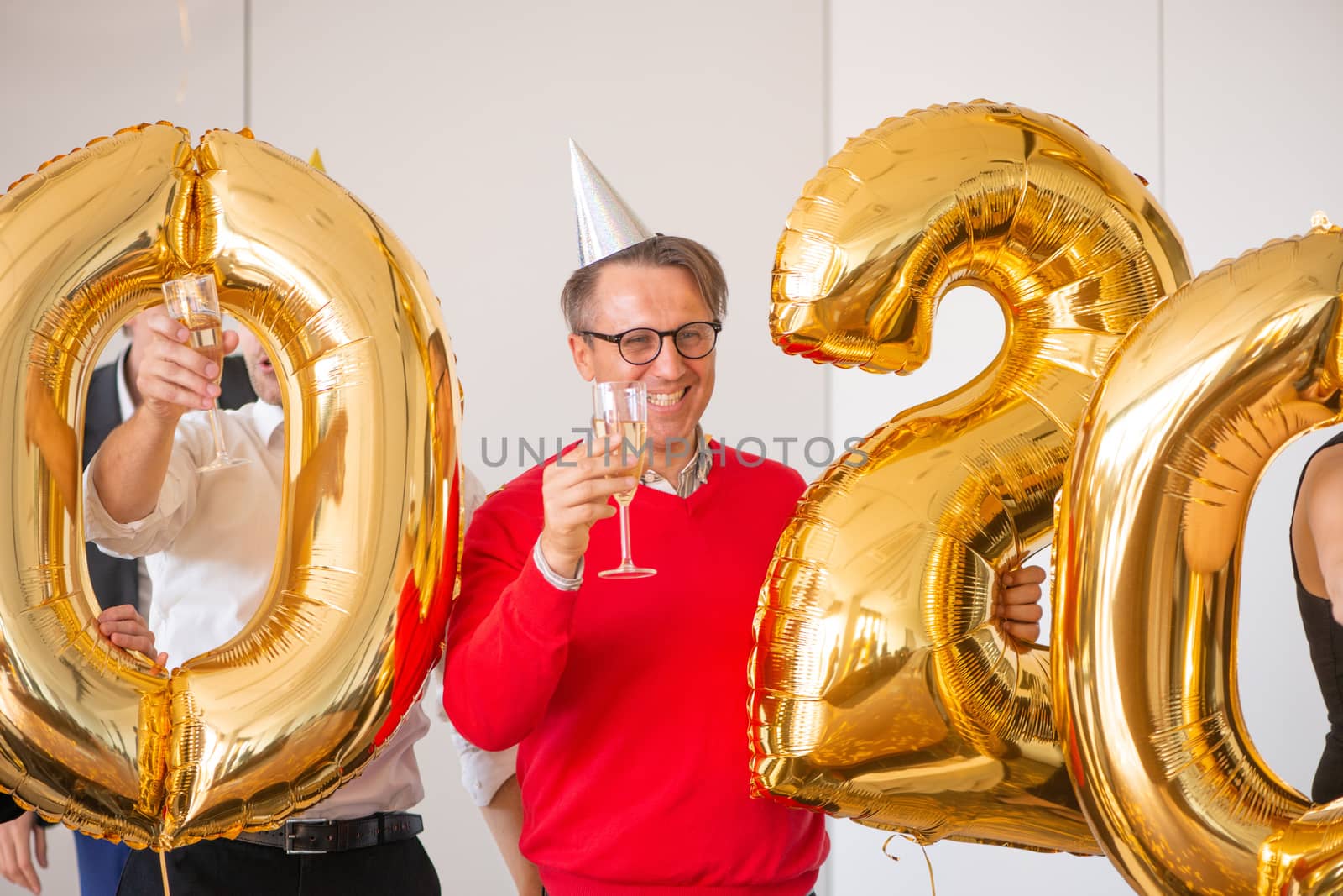 Business people are celebrating holiday in modern office drinking champagne and having fun in coworking. Merry Christmas and Happy New Year 2020 concept