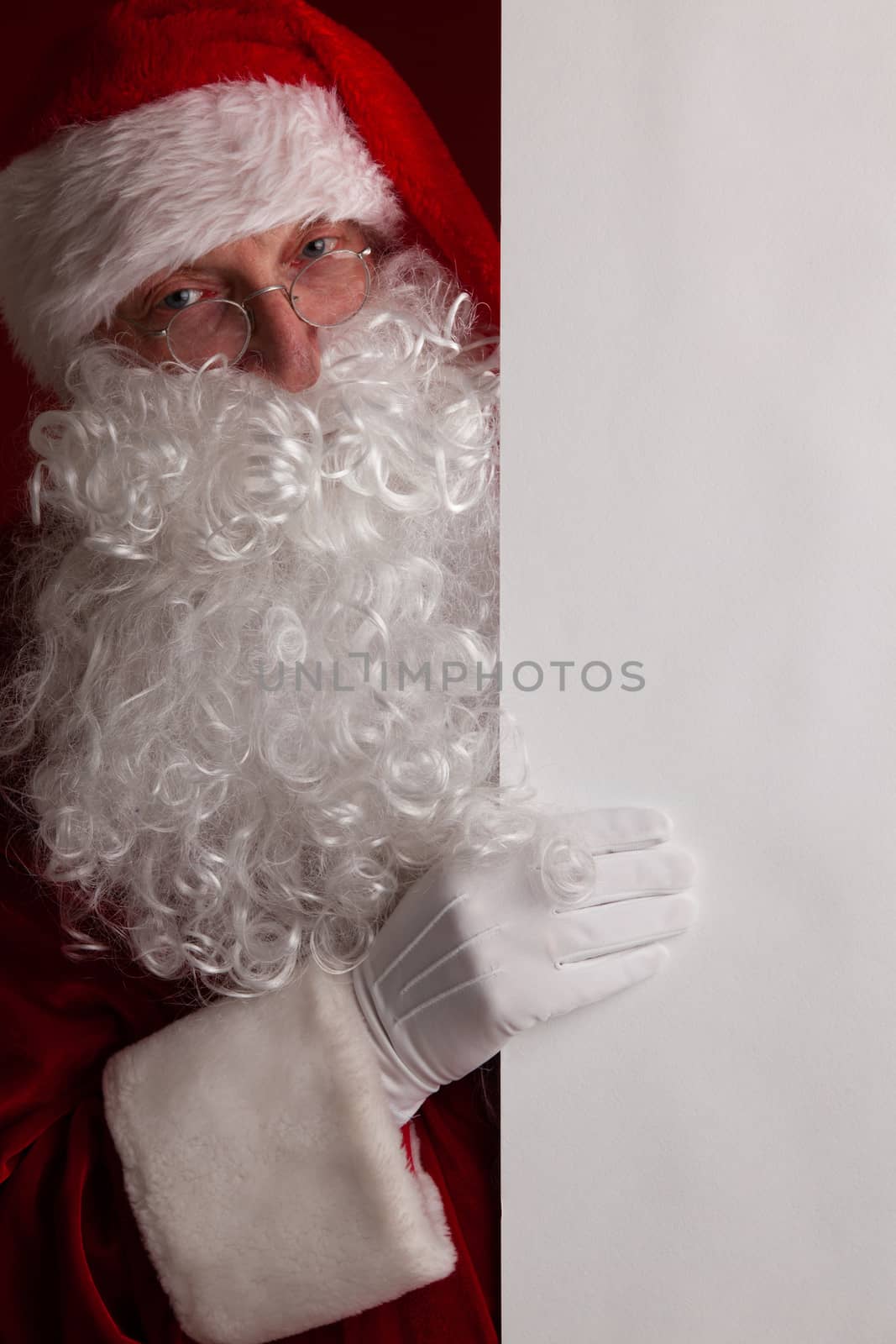 Santa Claus holding white paper billboard with copy space for text