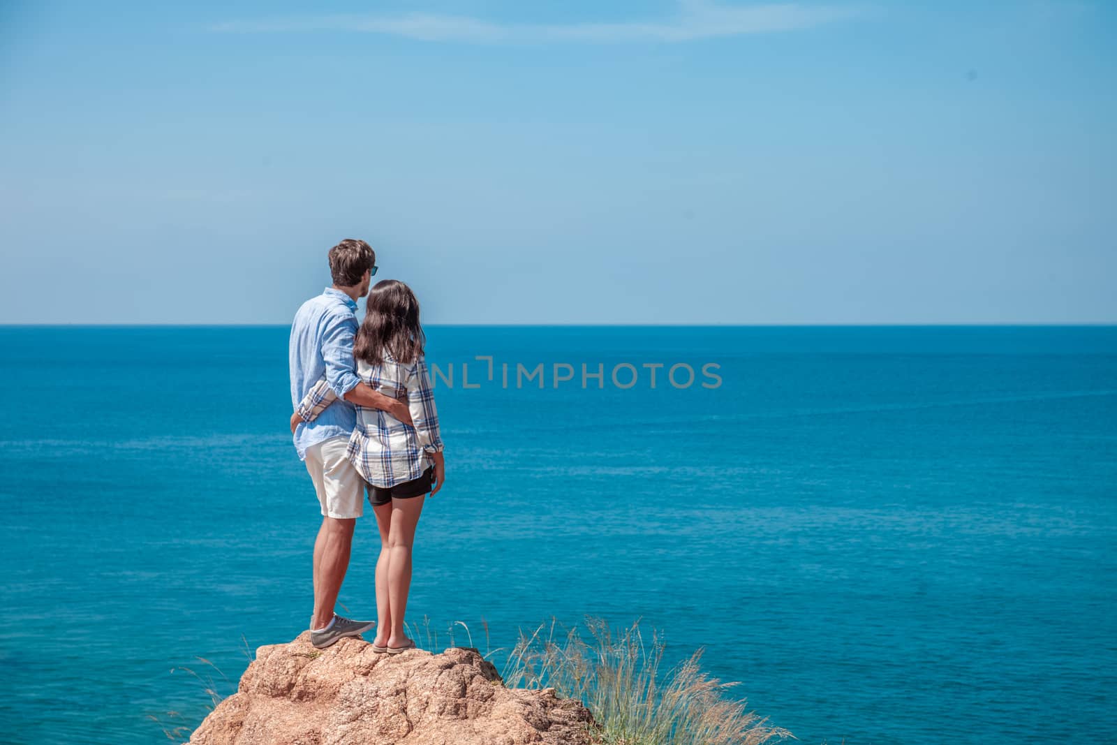 Young couple look at sea by ALotOfPeople