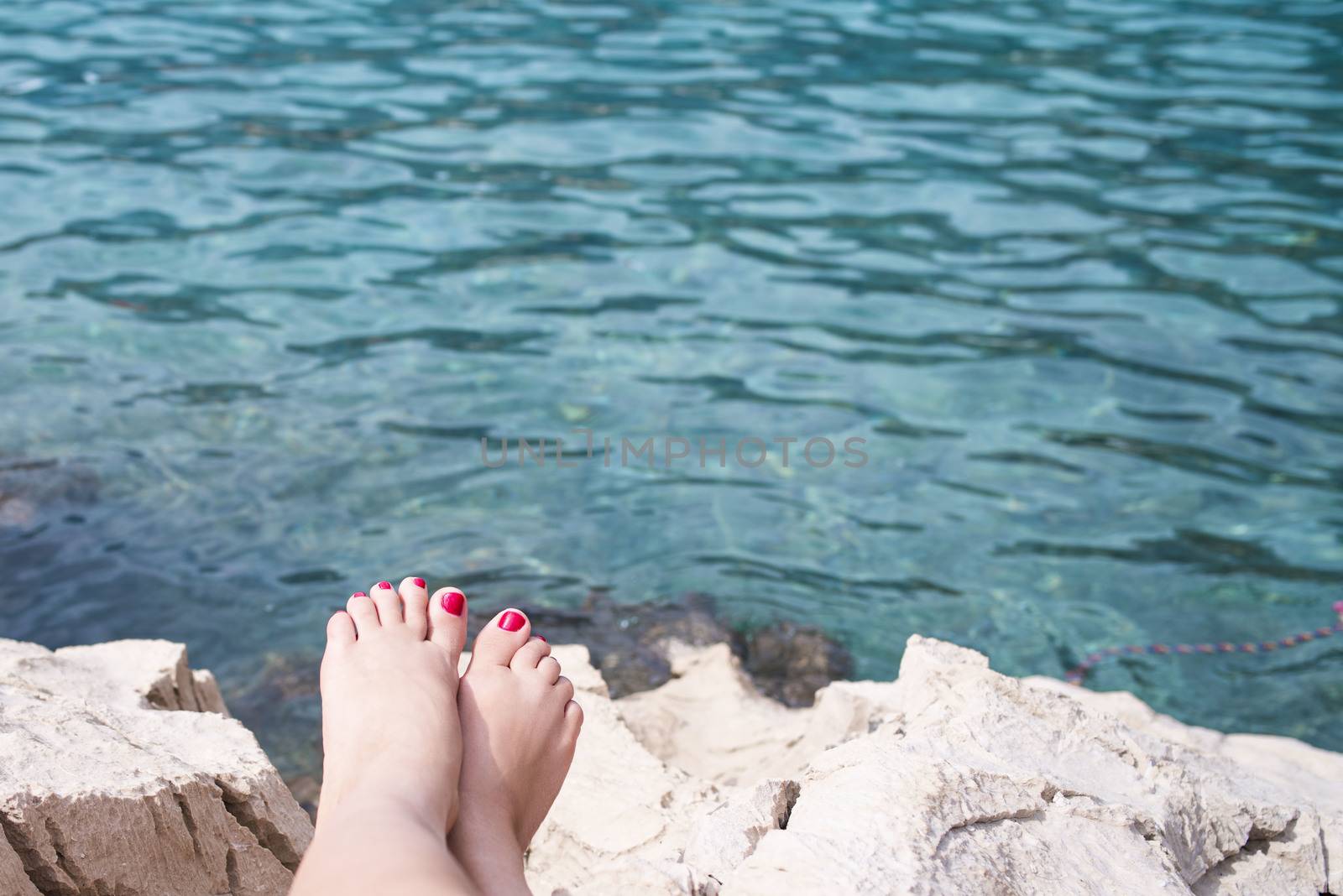 Vacation concept, women foot near sea foam, gold sand