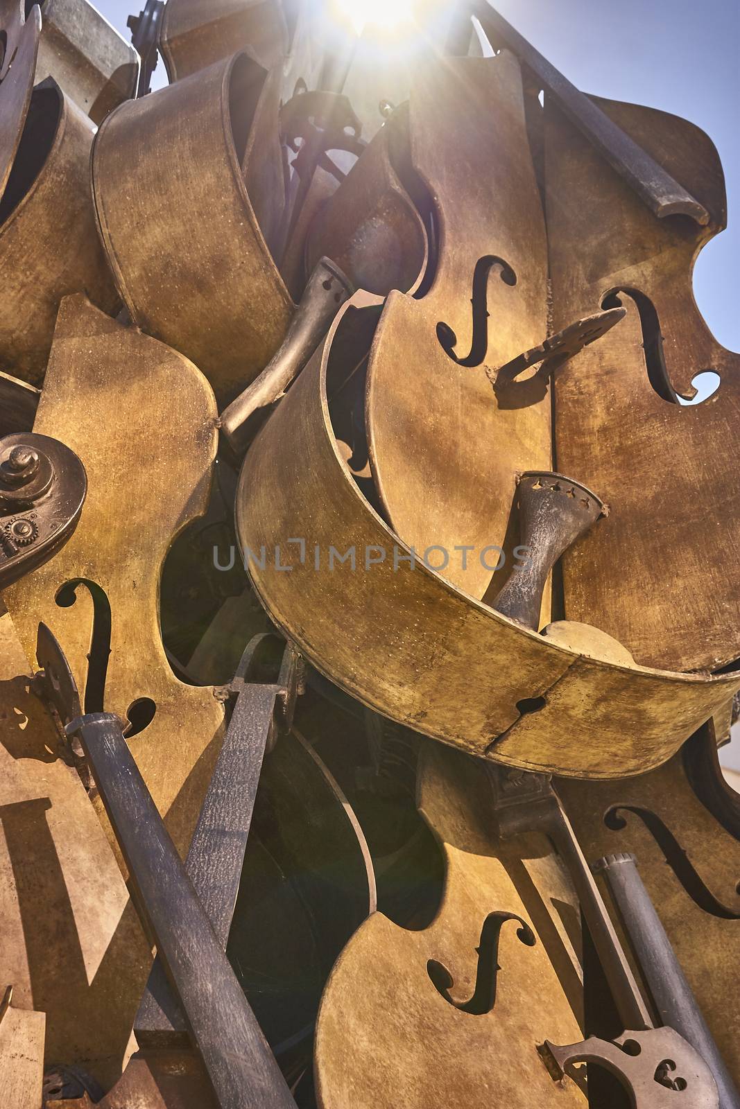 Old vintage violins are now reduced to pieces and packed in a unique pile. Vertical Shot.