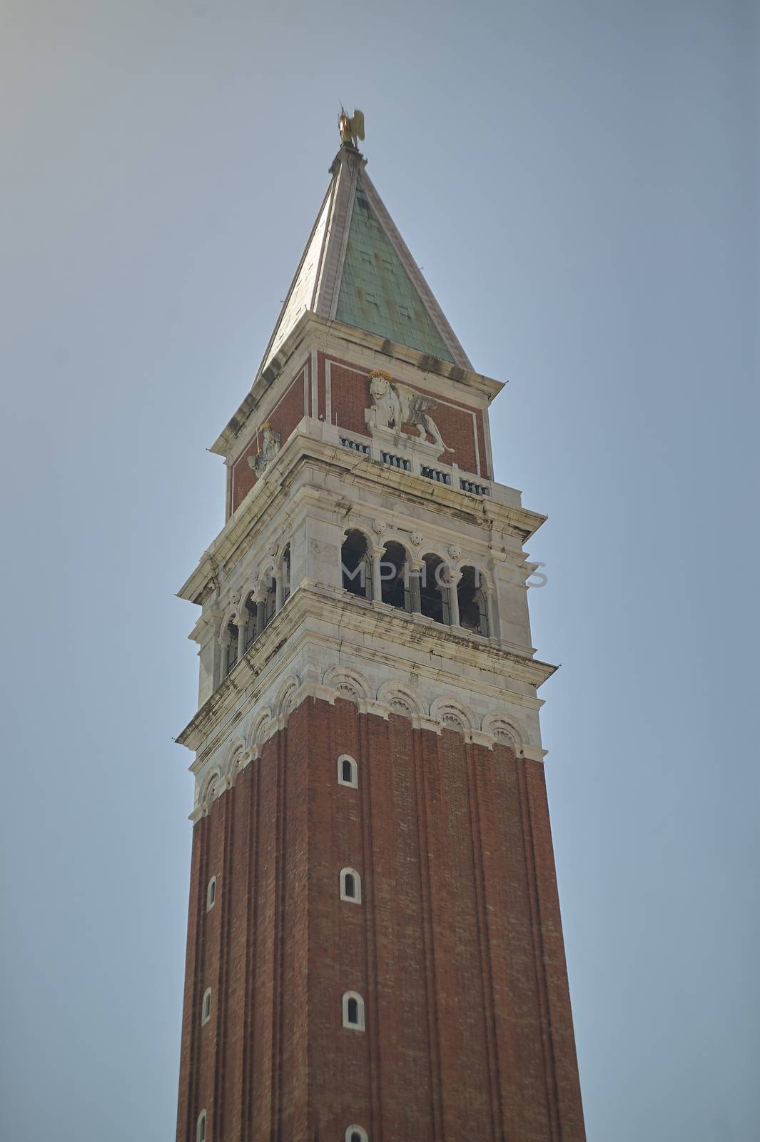 Top of the bell tower of St. Mark's Church in Venice with blue sky background