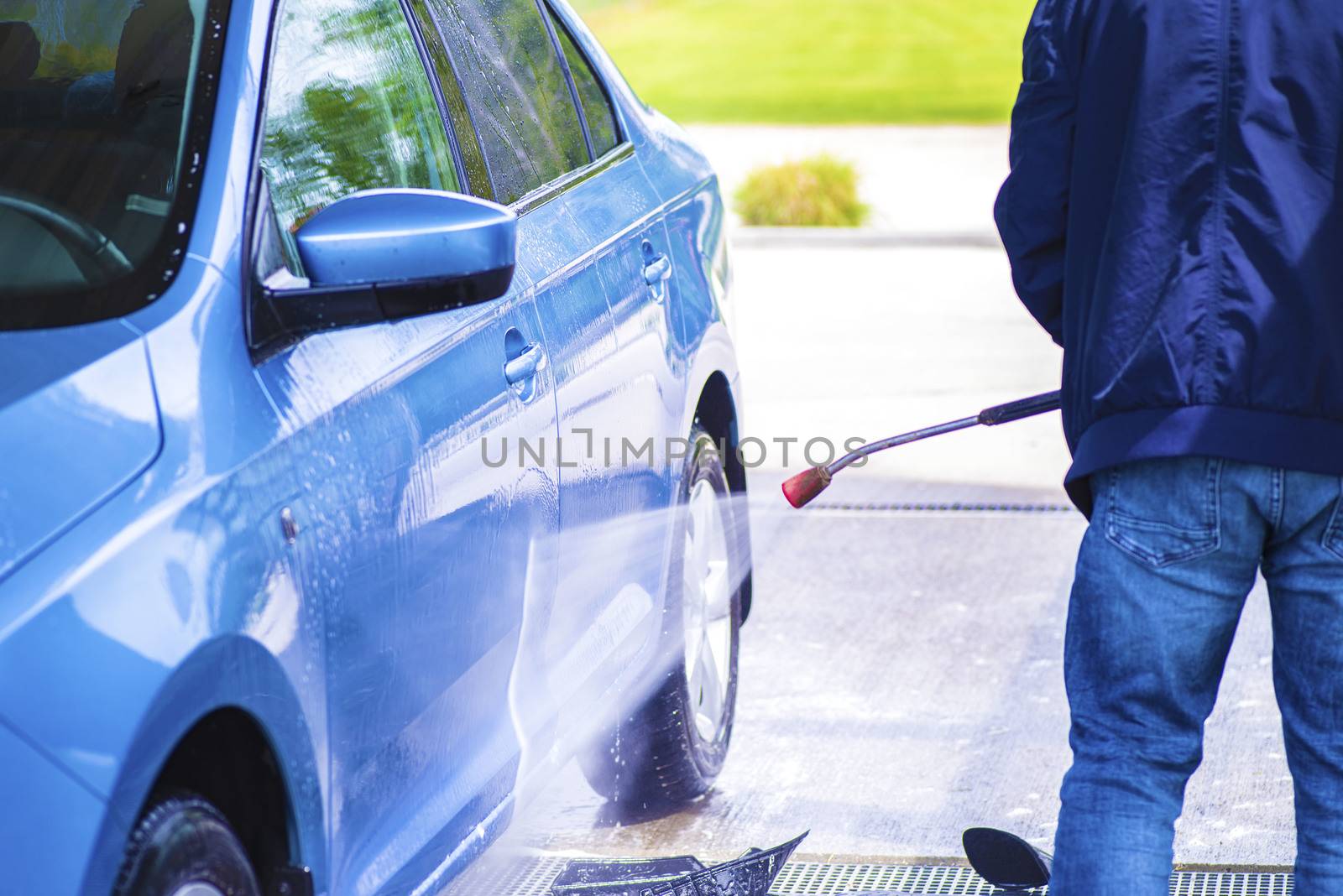 Cleaning Car Using High Pressure Water.Manual car wash with pressurized water in car wash outside.