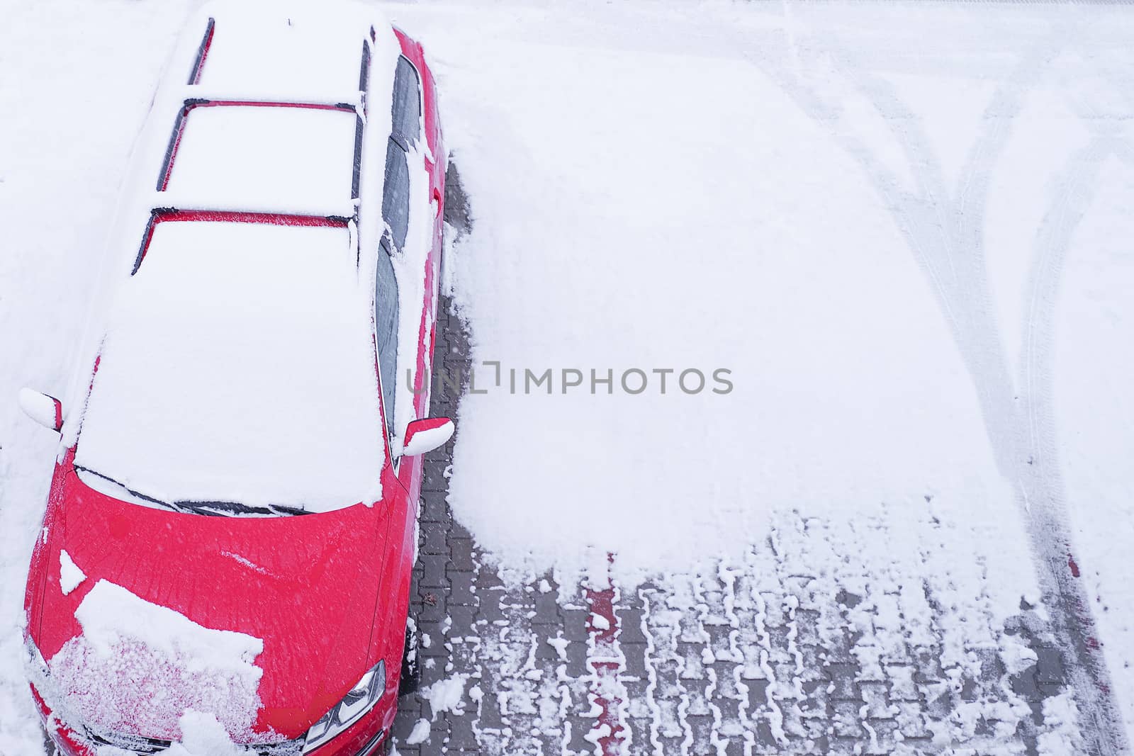 Car under snow in winter.A red car is parked in the snow. Snowfall. Winter season.